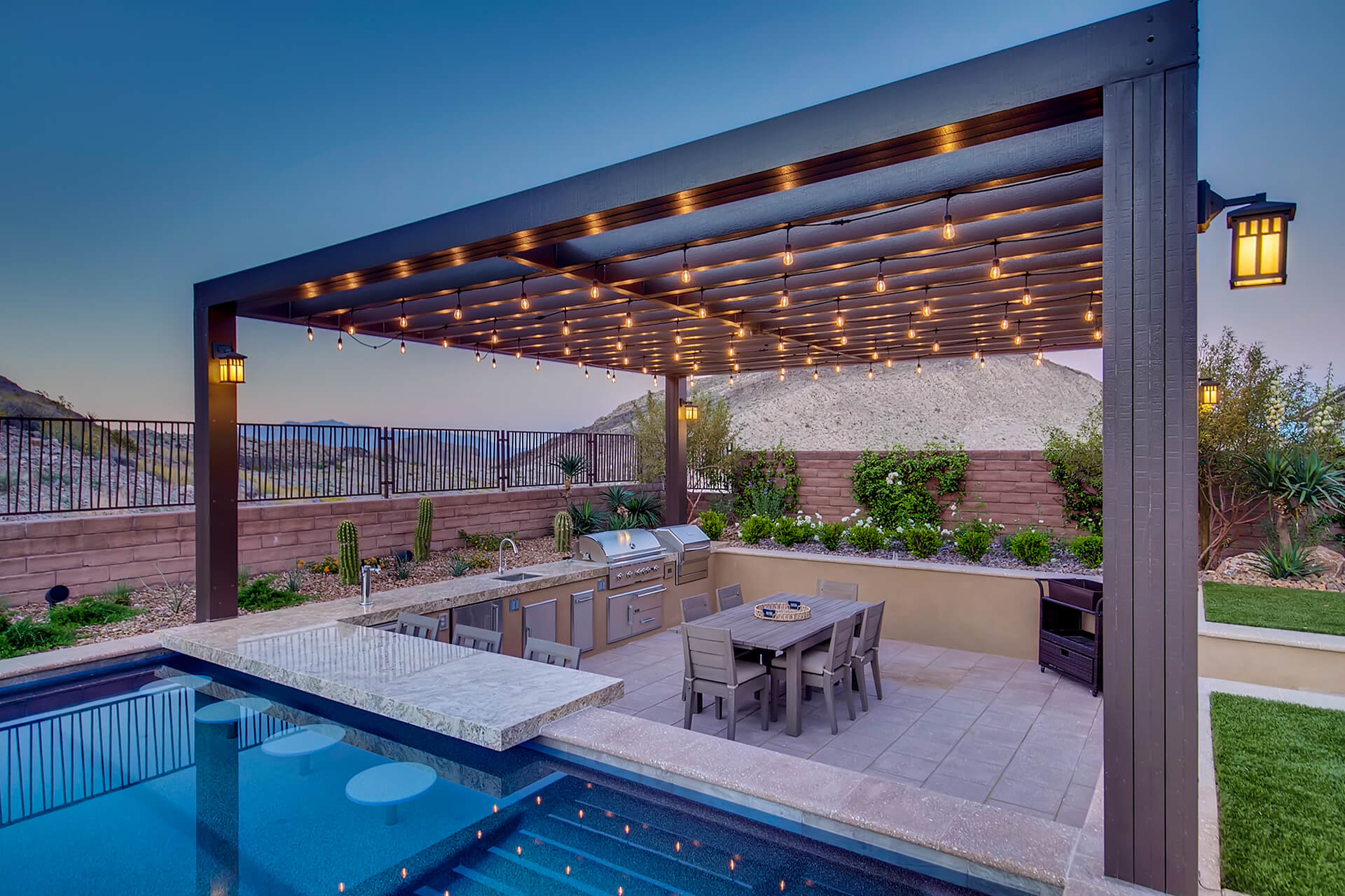 A pool and patio with lights above the table.