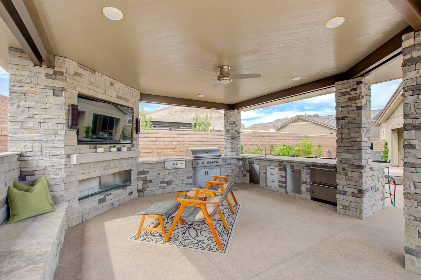 A patio with an outdoor fireplace and television.