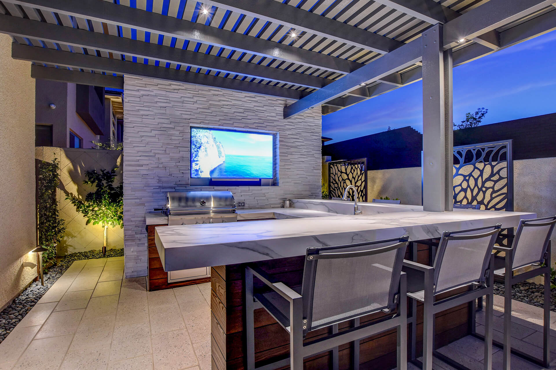 A television is on in the back of an outdoor patio.
