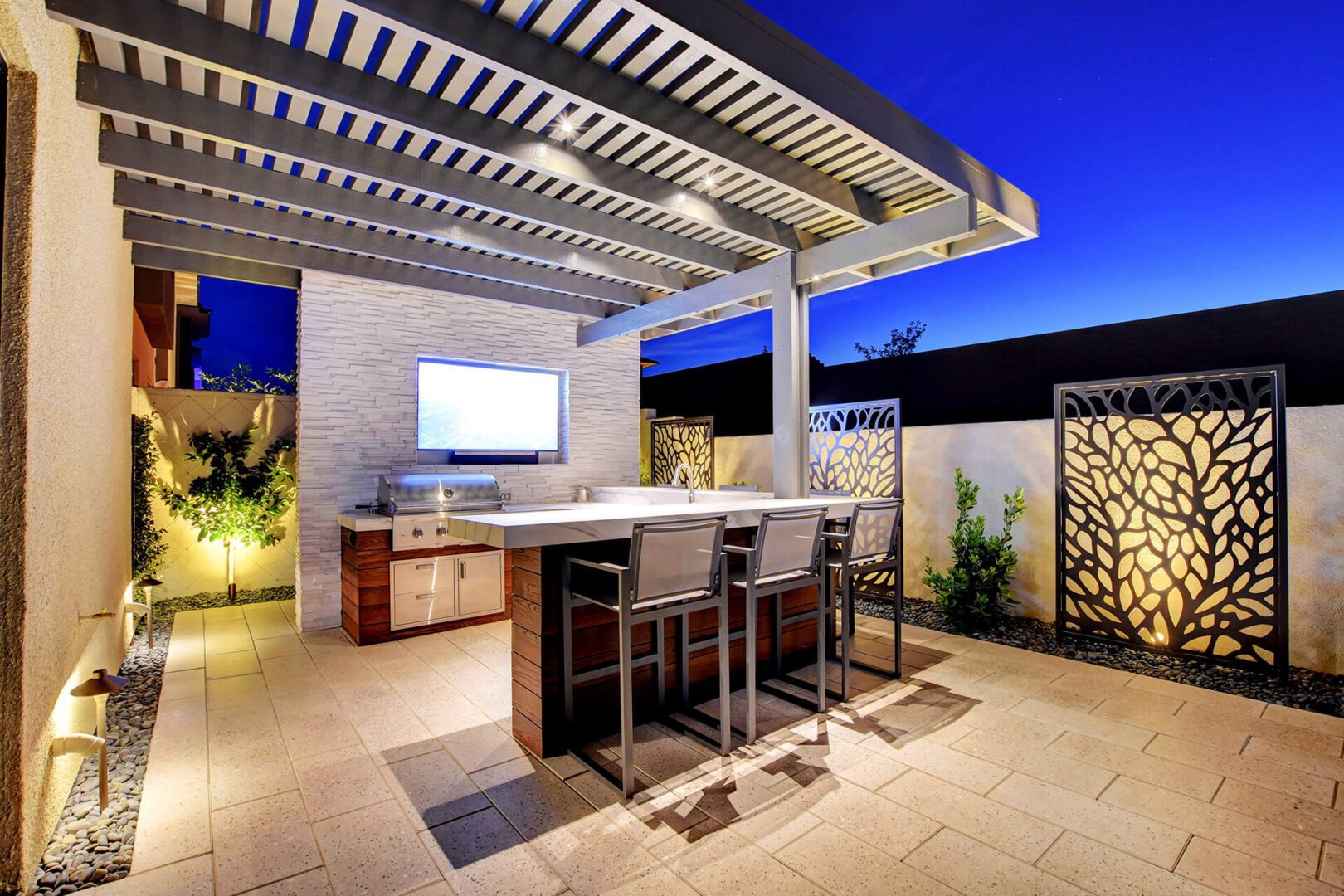 Beautiful Custom Outdoor Living Area with Thermory T&G Ash Cladding Outdoor Kitchen Finish, Duralum Attached Lattice Patio Cover, and Stacked Stone Finished Media Wall